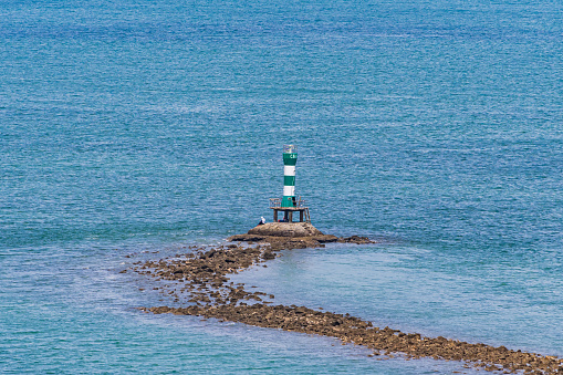 Lighthouse searchlight beam through sea air in Vung Tau. Seascape at morning