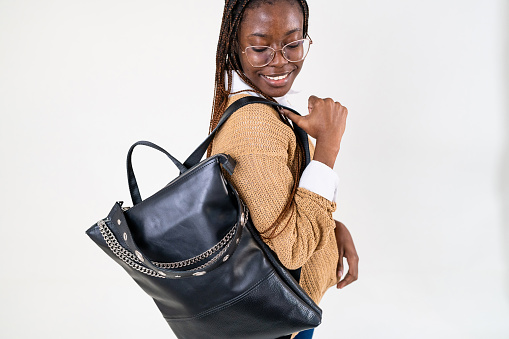 Young female fashion model Black ethnicity, carrying an leather backpack