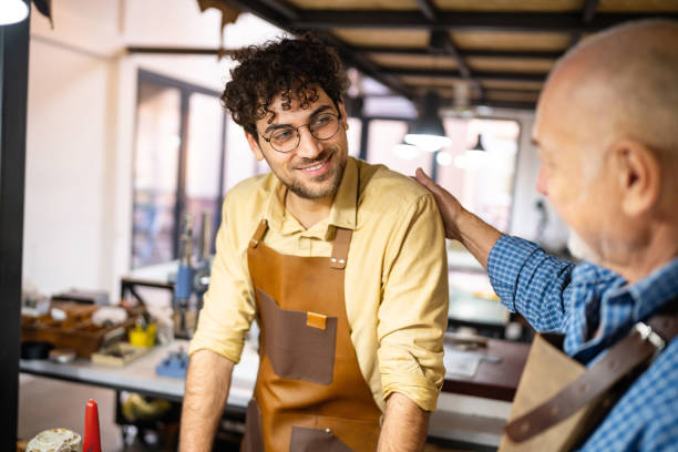 istock Proud senior male tailor sharing his knowledge and experience with his son, an trainee 1867212047
