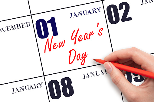 January 1. Hand writing text New Year's Day on calendar date. Save the date. Holiday. Day of the year concept.