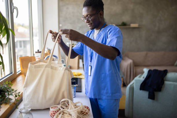 Young male nurse wearing medical scrubs bringing groceries home