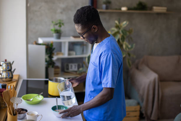 Young male nurse making himself breakfast at home
