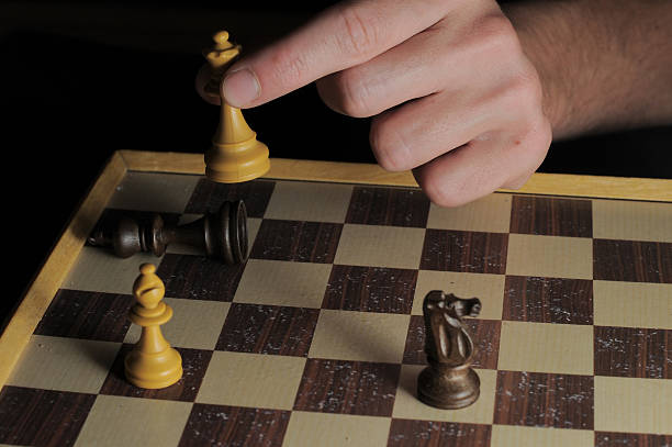 une main gauche homme jouant aux échecs - chess board room business strategy photos et images de collection