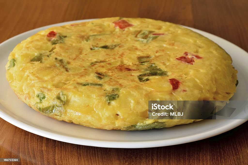 omelet Omelette with red and green peppers on a white plate and wooden table Spanish Omelet Stock Photo