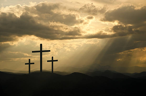 istock Rays of sun through the clouds on three black crosses 186723370