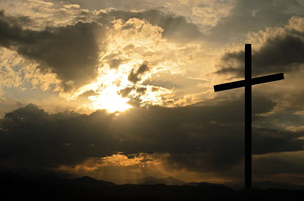 istock Backlit silhouette of a cross on a hill at sunset 186723398