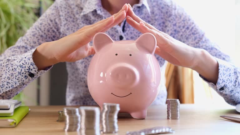 Insurance agent woman holds hands on piggy bank