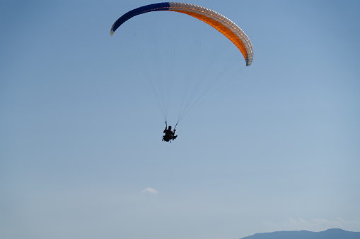 The sportsman flying on a paraglider. Beautiful paraglider in flight on a white background. isolated