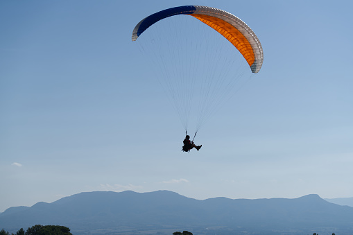 Paraglider in the blue sky. The sportsman flying on a paraglider.