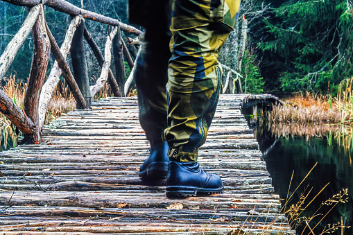Soldier walking across a bridge in the forest