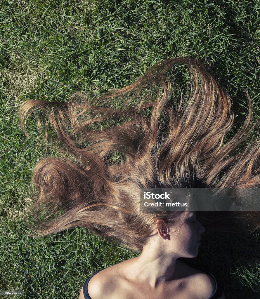 Una ragazza bellissima è sdraiato su un Erba verde - Foto stock royalty-free di Adulto