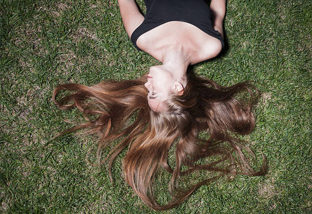 istock beautiful young girl is lying on green grass 186724830