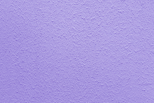 Lilac wall of the building. Rough plaster surface. Abstract background.