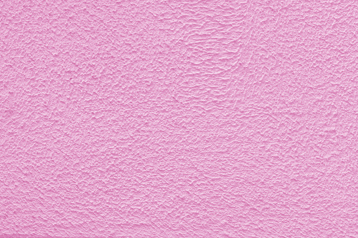 Pink plaster wall of a building. Rough surface texture.