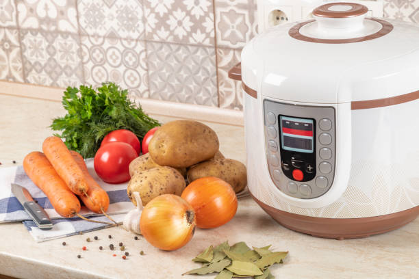 istock Modern, light multi cooker and raw products on table in kitchen. Cooking stewed potatoes with meat in multicooker. 1867259313