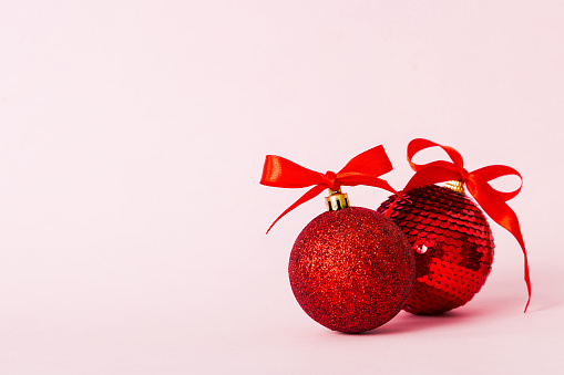 Christmas ball on colored background. decoration bauble with ribbon bow with copy space.