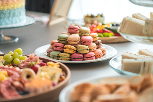 A sumptuous selection of assorted macarons adds a splash of color and sweet indulgence to the baby shower buffet.