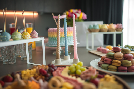 A beautifully curated baby shower celebration with a stunning pastel cake, delicate macarons, and an array of elegant snacks.