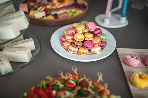 A sumptuous selection of assorted macarons adds a splash of color and sweet indulgence to the baby shower buffet.