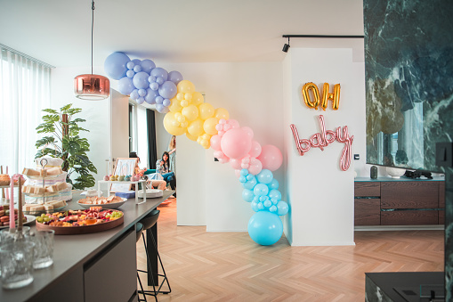 A modern baby shower display featuring a colorful cake and a selection of refreshments, encapsulating contemporary entertaining.