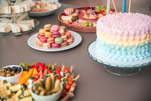 An inviting baby shower table boasts personalized pastries, colorful macarons, and a selection of savory appetizers for the guests.