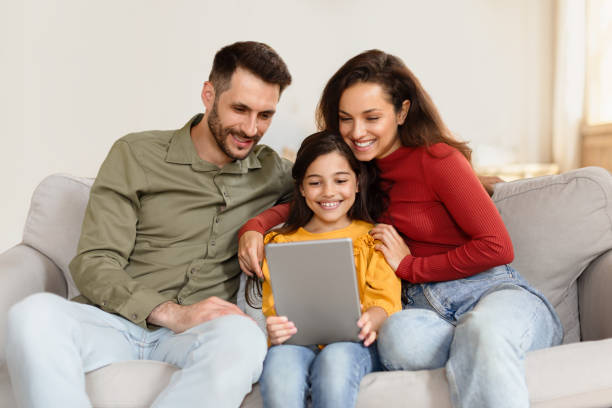 istock Happy mom, dad and daughter using digital tablet at home 1867282526