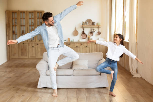 istock Joyful daddy and daughter dancing doing funny moves at home 1867283050