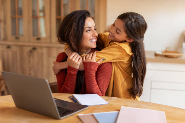istock Arab Daughter Embracing Mom While She Using Laptop At Home 1867283098