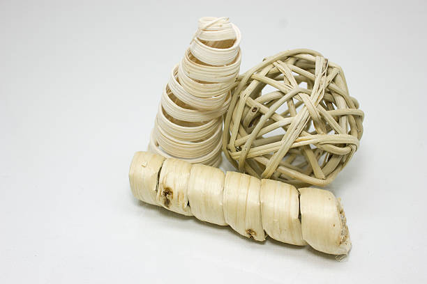 A wooden weaved ball and two wood shavings rest elegentally.