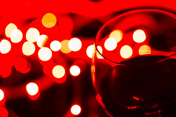 glass of wine with defocused lights on dark background