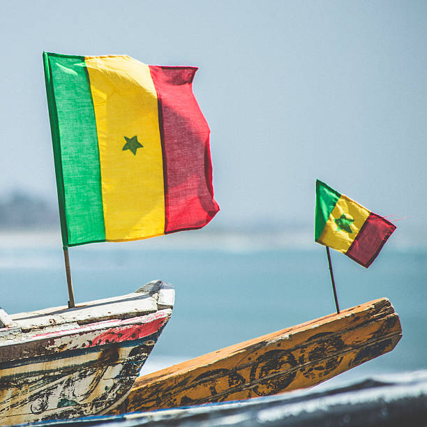 セネガル旗のフィッシングボートます。 - flag of senegal ストックフォトと画像