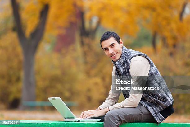 Programmer With Notebook Sitting In Autumn Park Stock Photo - Download Image Now - Adult, Adults Only, Autumn