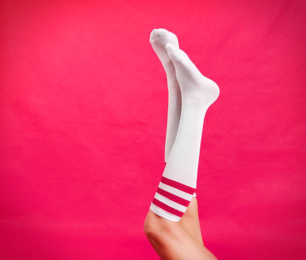 Woman's legs wearing pink striped tube socks.