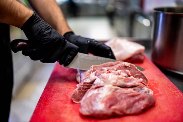istock Chef Butcher cutting beef meat with knife on kitchen 1867297789
