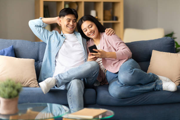 istock Happy Japanese spouses browsing internet at cozy home 1867301042