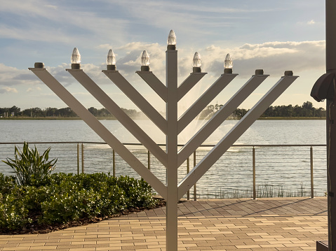 A hanukkiah for observance of the eight-day Jewish festival of Hanukkah on a community terrace near a fountain on a lake in southwest Florida. (Seen here on the third day of Hanukkah.)