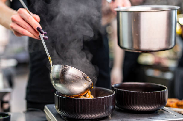 istock chef pouring tasty soup from pot into bowl on kitchen 1867320244
