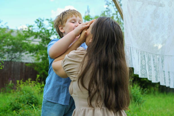 istock home backyard, a mother and her small red-haired son playfully interact and embrace. This natural moment demonstrates the impact of familial relationships on children s mental health. 1867321896