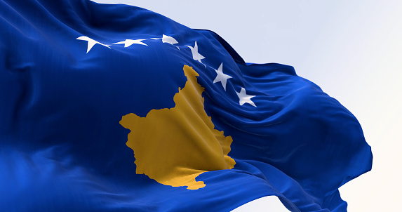 Close-up of Kosovo national flag waving. Six white stars above a golden map of Kosovo in a blue field. 3d illustration render. Rippling textured fabric.