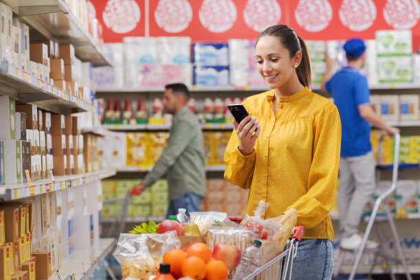 istock Happy customer doing grocery shopping and using her smartphone 1867329492