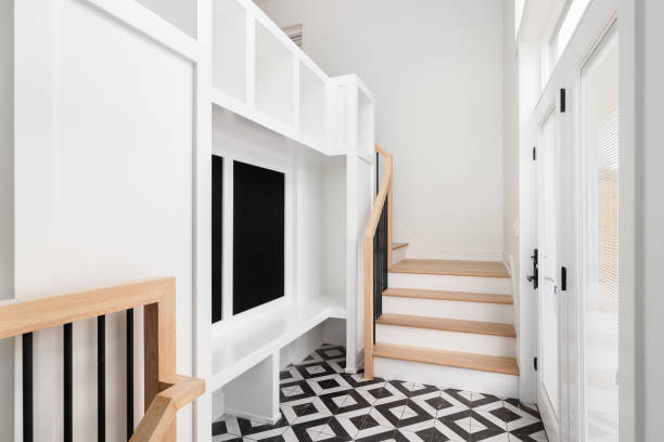 istock A large foyer with a white built-in storage unit and black and white tile flooring. 1867333792