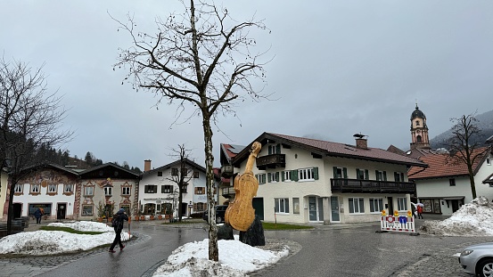 Mittenwald, Germany - December, 14th - 2023: Violin monument at a square. The town of violin makers has erected a monument to this instrument.