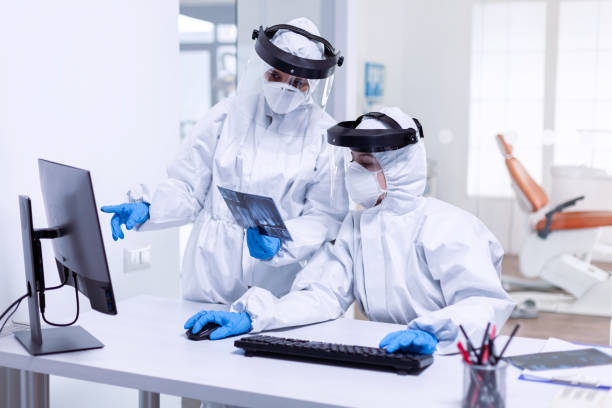 istock Tired dentistiry team dressed in ppe suit during covid-19 1867343081