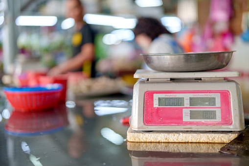 Close-up of weighing scales at an Asian morning market stall. The scales used for measuring and weighing various items sold at the market. It provides a glimpse into the traditional market setting and the tools commonly used by vendors for their trade.