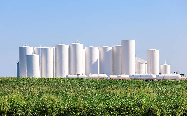 Metal tanks storing Anhydrous Ammonia Rural scene showing large grouping of metal tanks used to store ammonia for farm usage. ammonia fertilizer stock pictures, royalty-free photos & images