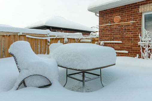 Heavy snow accumulated on garden table and chairs