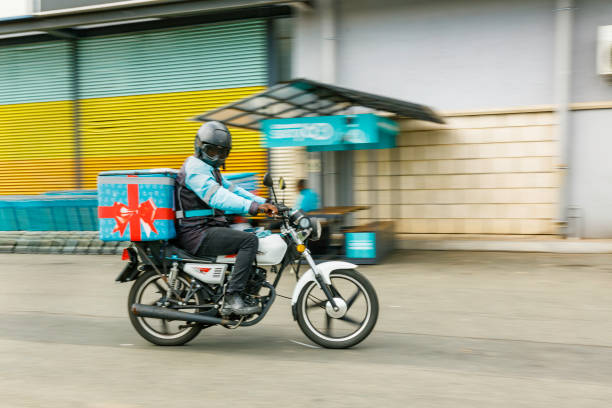 Motorcycle delivery man busy delivering the groceries to the internet customer in 60 minutes.