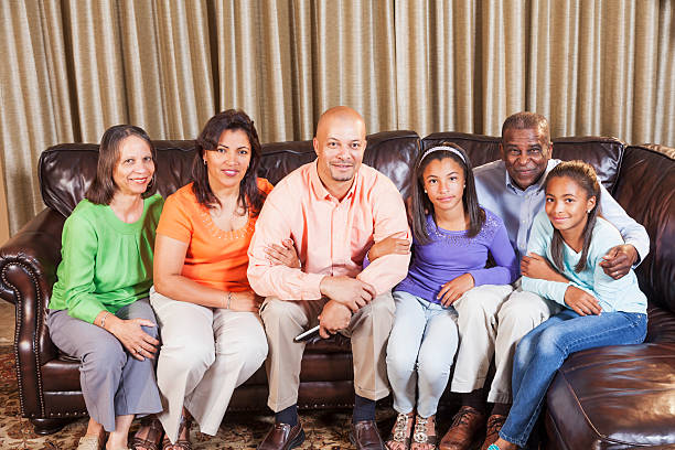 de várias gerações de família afro-americana sentada no sofá - 1960s style image created 1960s retro revival family - fotografias e filmes do acervo