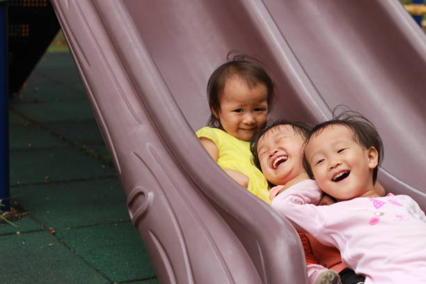 istock Three girls sliding down the slide together. 1867385946