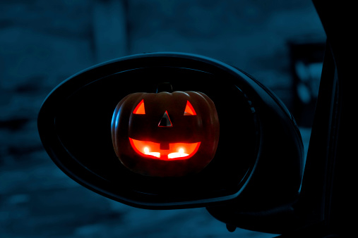 Jack-o'-Lantern seen in rearviewmirror of a car